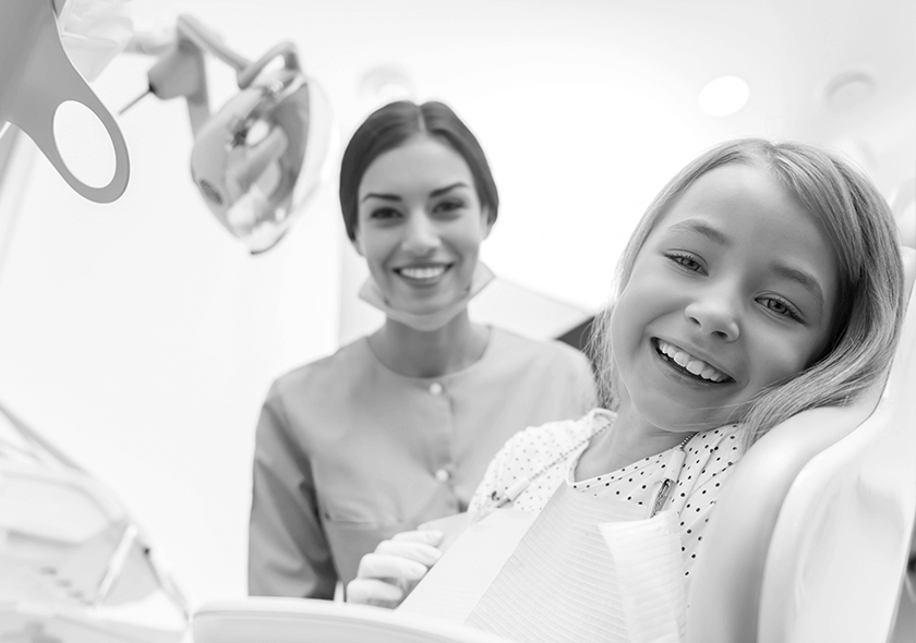 A child patient smiling alongside the dentist.